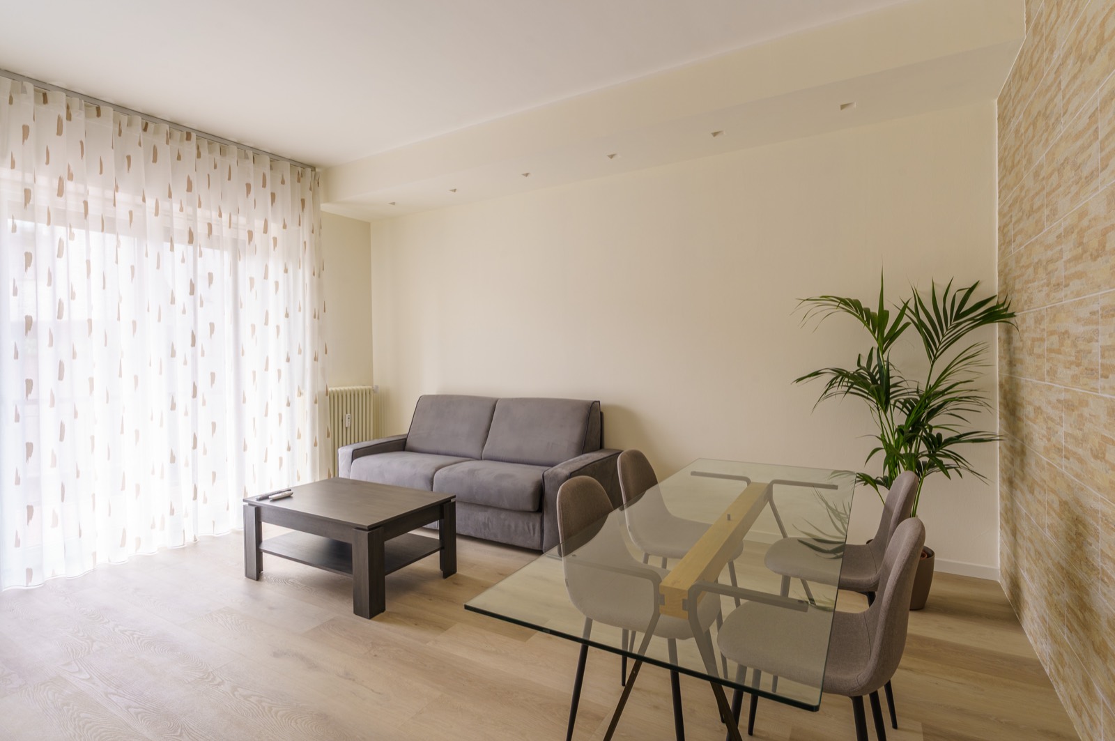 The bright living and dining area, with its stone wall – Bergamo Hideout, Bergamo